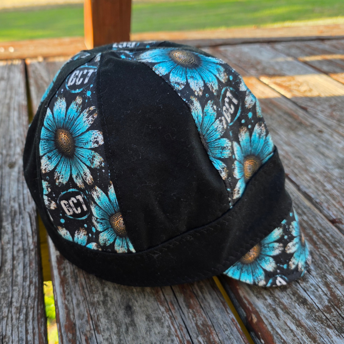 Handmade turquoise daisy reversible welding cap with BCT logo and black panels